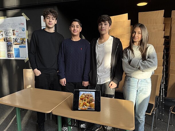 Vier Jugendliche präsentieren ihr Profilprojekt mit Tablet und Plakat