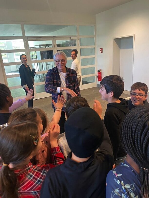 Mann spricht in der Ballettschule mit einer Gruppe von Kindern