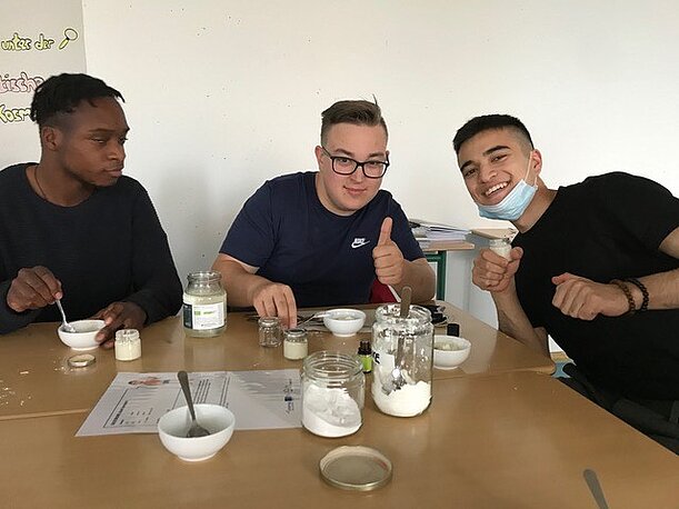Drei Schüler rühren am Tisch selbstgemachtes Deo aus Zutaten an