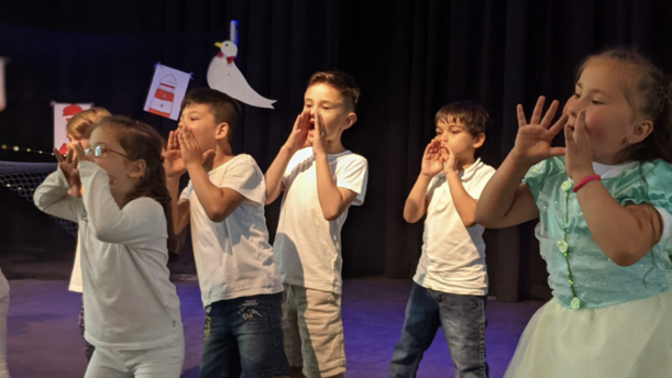 Vorschulkinder rufen gemeinsam auf der Bühne beim Theaterstück Flaschenpost
