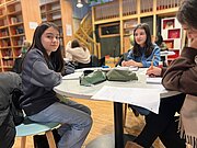 Schülerinnen schreiben im Enrichmentkurs Kreatives Schreiben am runden Tisch