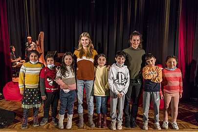 Kindergruppe steht mit Musikerinnen nach dem Kinderkonzert auf der Bühne