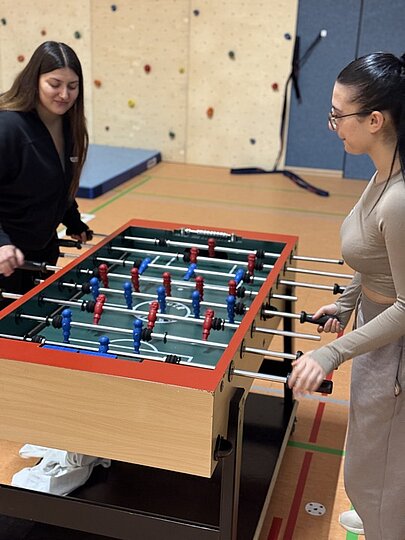 Zwei junge Frauen spielen Tischkicker beim OSW Sportfest am Perlstieg