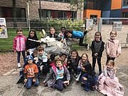 Grundschulkinder mit Müllgreifern und gesammeltem Abfall beim Aufräumtag