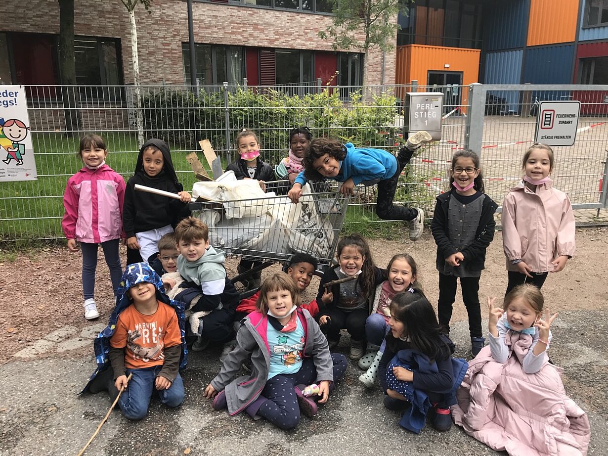 Grundschulkinder mit Müllgreifern und gesammeltem Abfall beim Aufräumtag