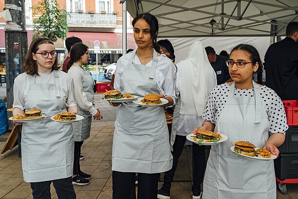 Schülerinnen servieren Burger auf dem Stübenplatz