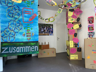 Bemaltes Banner mit Aufschrift Zusammen neben Kartonturm in der Galerie