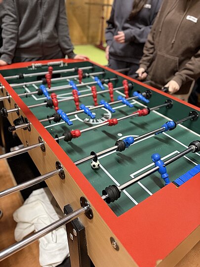 Nahaufnahme eines Tischkickers mit Spielenden beim Oberstufen-Sportfest