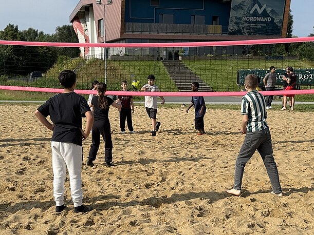 Jugendliche spielen Beachvolleyball im Sand im Inselpark