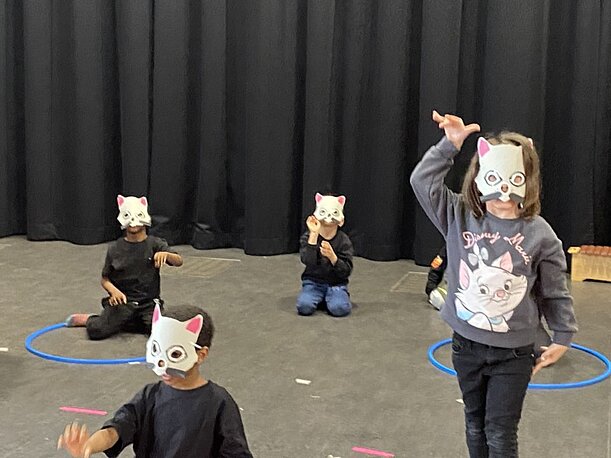 Vorschulkinder mit Katzenmasken tanzen beim Stück ABC die Katze