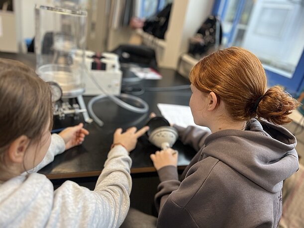 Zwei Schülerinnen experimentieren mit Glasgeräten im DESY-Labor