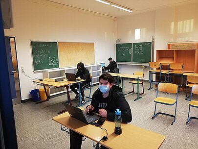Schüler programmiert mit Laptop im Klassenraum