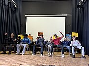 Profilgruppe Kultur, Movement und Bühne der 8d bei einer Präsentation auf Stühlen