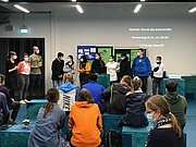 Gäste im ScienceCafé sitzen vor Leinwand und Stellwänden
