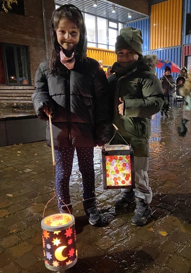 Amera und Amar mit bunten leuchtenden Laternen beim Laternenumzug
