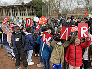 Schülerinnen und Schüler halten Buchstaben „STOP WAR“ auf dem Schulhof hoch