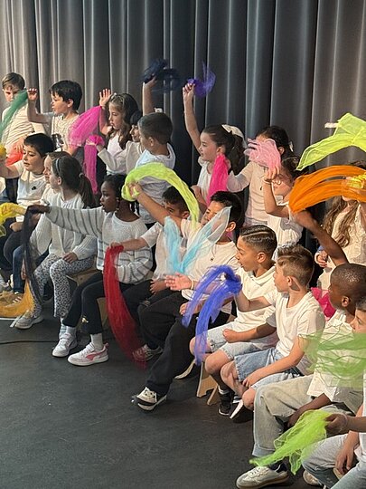 Kinder mit bunten Bändern und Perücken beim Sommerfest