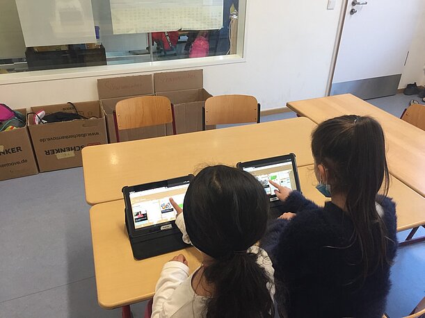 Zwei Kinder nutzen Tablets im Klassenraum