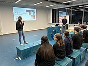 Koordinatorin begrüßt Publikum beim ScienceCafé zum Thema Künstliche Intelligenz