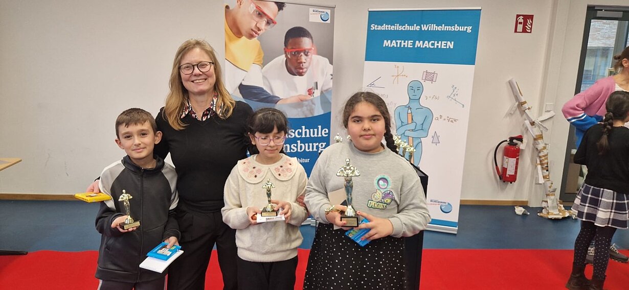 Katja Schlünzen mit drei Mathe-Oscar-Gewinnern und ihren Pokalen