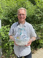 Verkehrspolizist Thorsten Pagel mit Geschenkkorb zum Abschied im Grünen