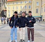 Drei Jugendliche des Schulsprecherteams auf einem Platz vor historischem Gebäude