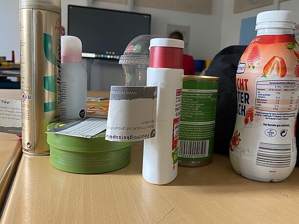 Deo, Spray, Milchgetränk und Kosmetikdosen auf einem Tisch im Chemikalien-Workshop