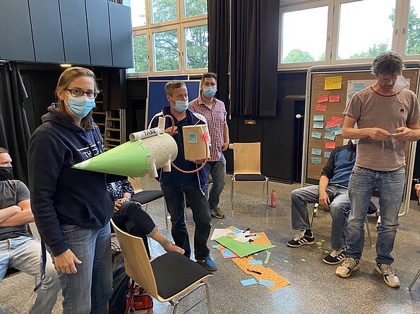 Lehrkräfte arbeiten stehend mit Bastelmaterial im Workshop