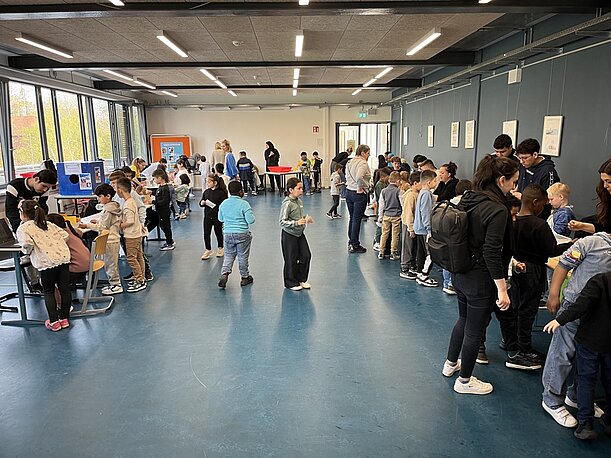 Kinder und Betreuende in einem großen Raum bei der Forscherwoche