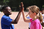 Grundschüler und Grundschülerin geben sich zu Spielbeginn ein High Five