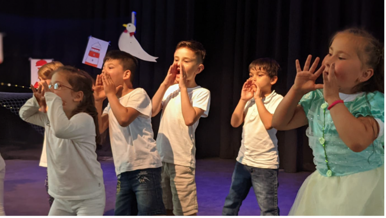 Vorschulkinder rufen mit Händen am Mund bei der Theateraufführung