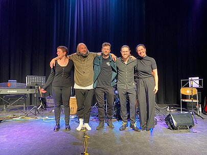 Band und Jury Arm in Arm auf der Bühne nach dem Wettbewerb