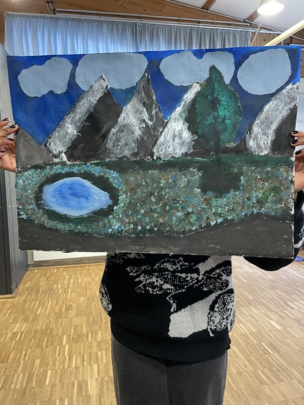 Gemälde einer Berglandschaft mit See wird hochgehalten