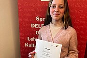 Malou hält beim Instituto Cervantes ihre Urkunde für den Spanisch-Lesewettbewerb