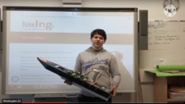 Schüler präsentiert ein Bootsmodell vor einem Whiteboard