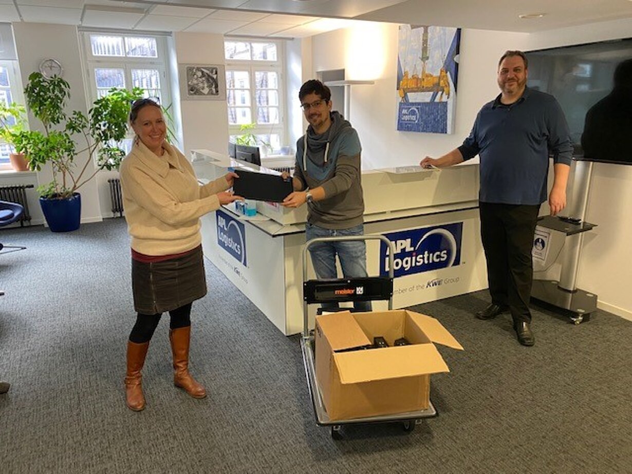 Übergabe eines Laptop-Pakets bei APL Logistics