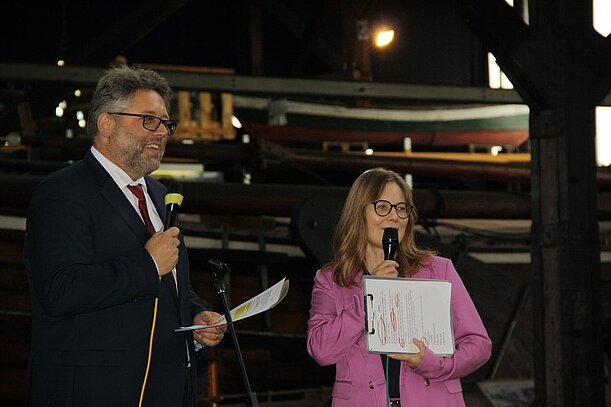 Matthias Herpe und Katja Schlünzen sprechen mit Mikrofonen im Hafenmuseum