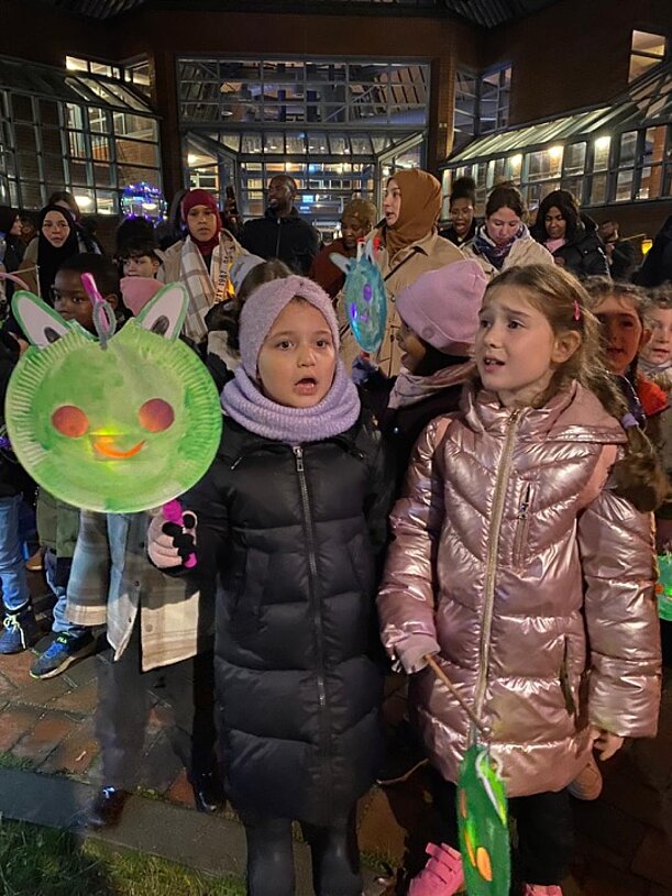 Alicyah mit anderen Kindern und Laternen beim abendlichen Laternenumzug
