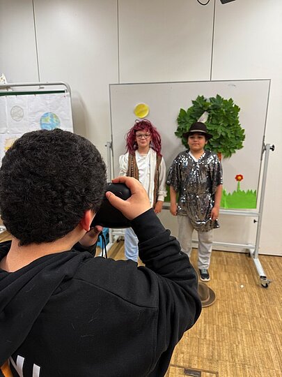 Schüler fotografiert verkleidete Kinder an einer Fotowand