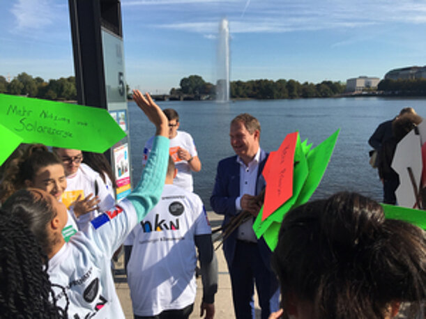 Jugendliche mit Klimaschildern an der Binnenalster mit Fontäne