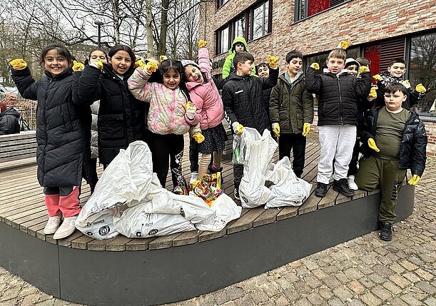 Klasse 2d mit Handschuhen und vollen Müllsäcken nach der Sammelaktion