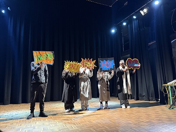 Theaterprofil auf der Bühne mit bunten Comic-Sprechblasen, Totale