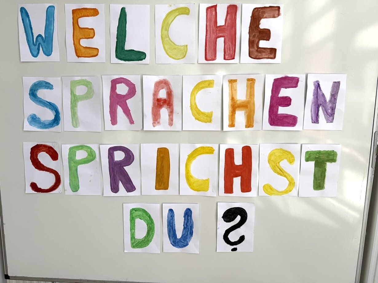 Bunte gemalte Buchstaben: „Welche Sprachen sprichst du?“