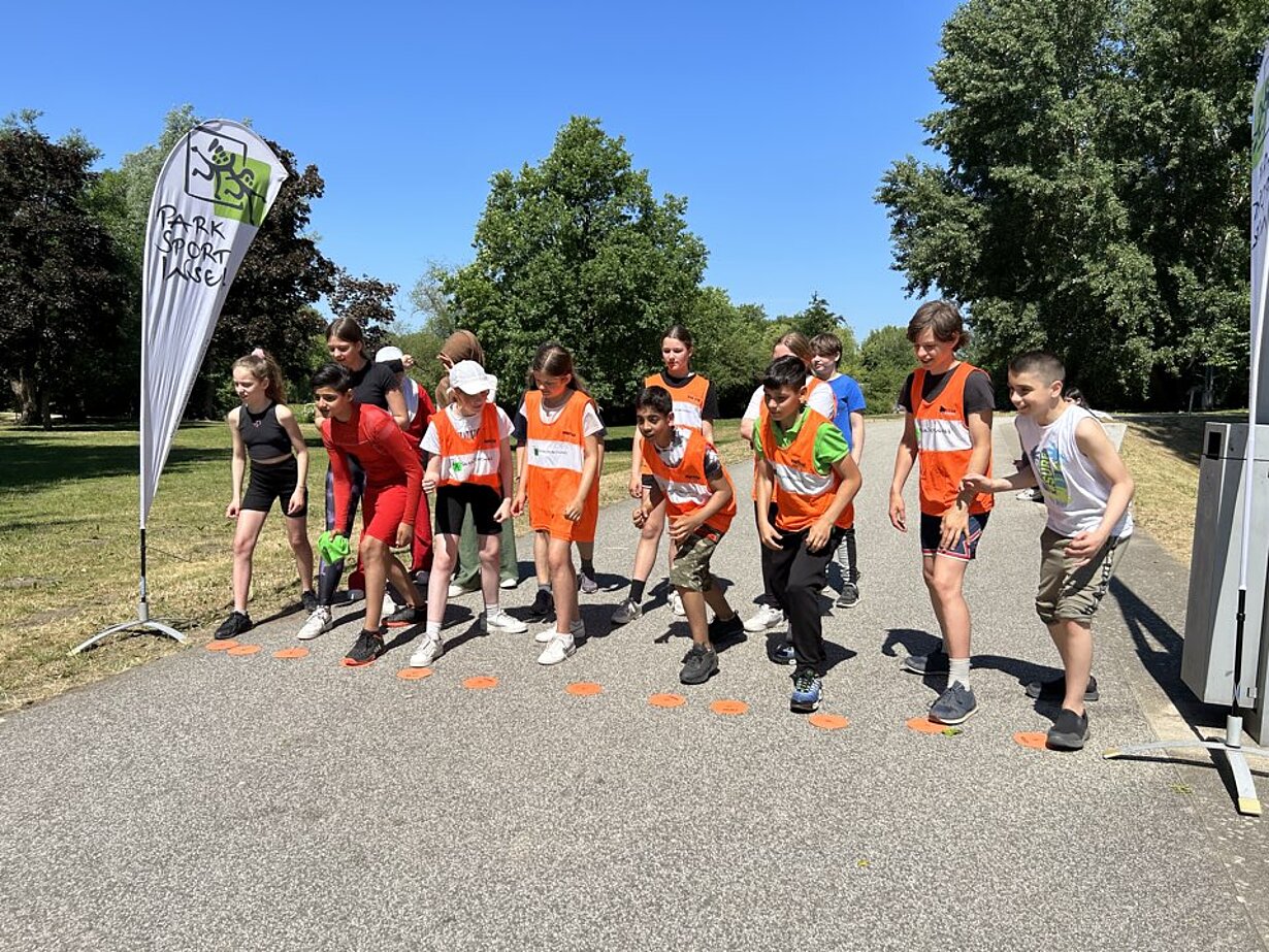 Schülerinnen und Schüler in Warnwesten am Start des Biathlons im Park