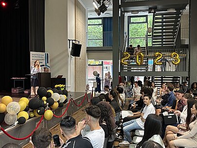 Rednerin am Pult, Publikum im geschmückten Saal mit Dekoration 2023