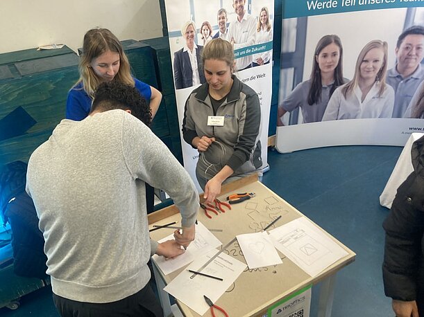 Schüler löst eine handwerkliche Aufgabe am Stand eines Ausbildungsbetriebs