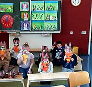 Vorschulkinder mit gebastelten Osterhasen-Masken im Klassenraum