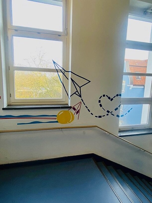 Tape-Art an Flurwand: Papierflieger mit gestrichelter Flugbahn und Herz