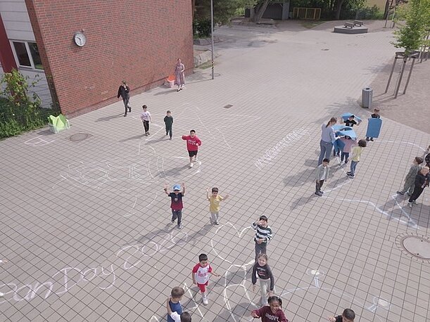 Schulhof mit Kreidebildern und Kindern zum World Ocean Day