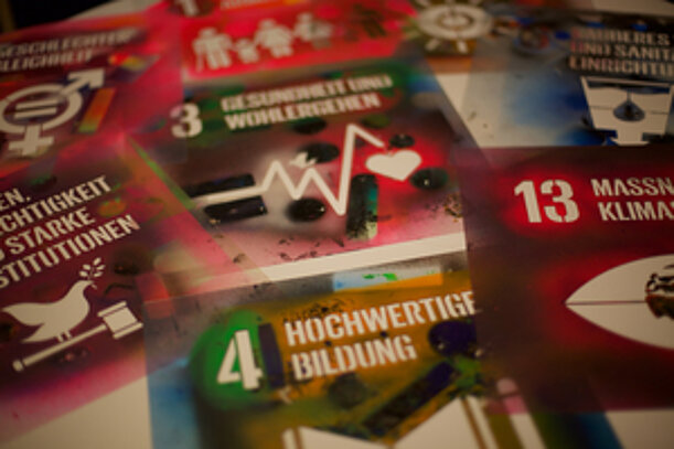 Flyer mit Symbolen der Nachhaltigkeitsziele wie Hochwertige Bildung und Klimaschutz